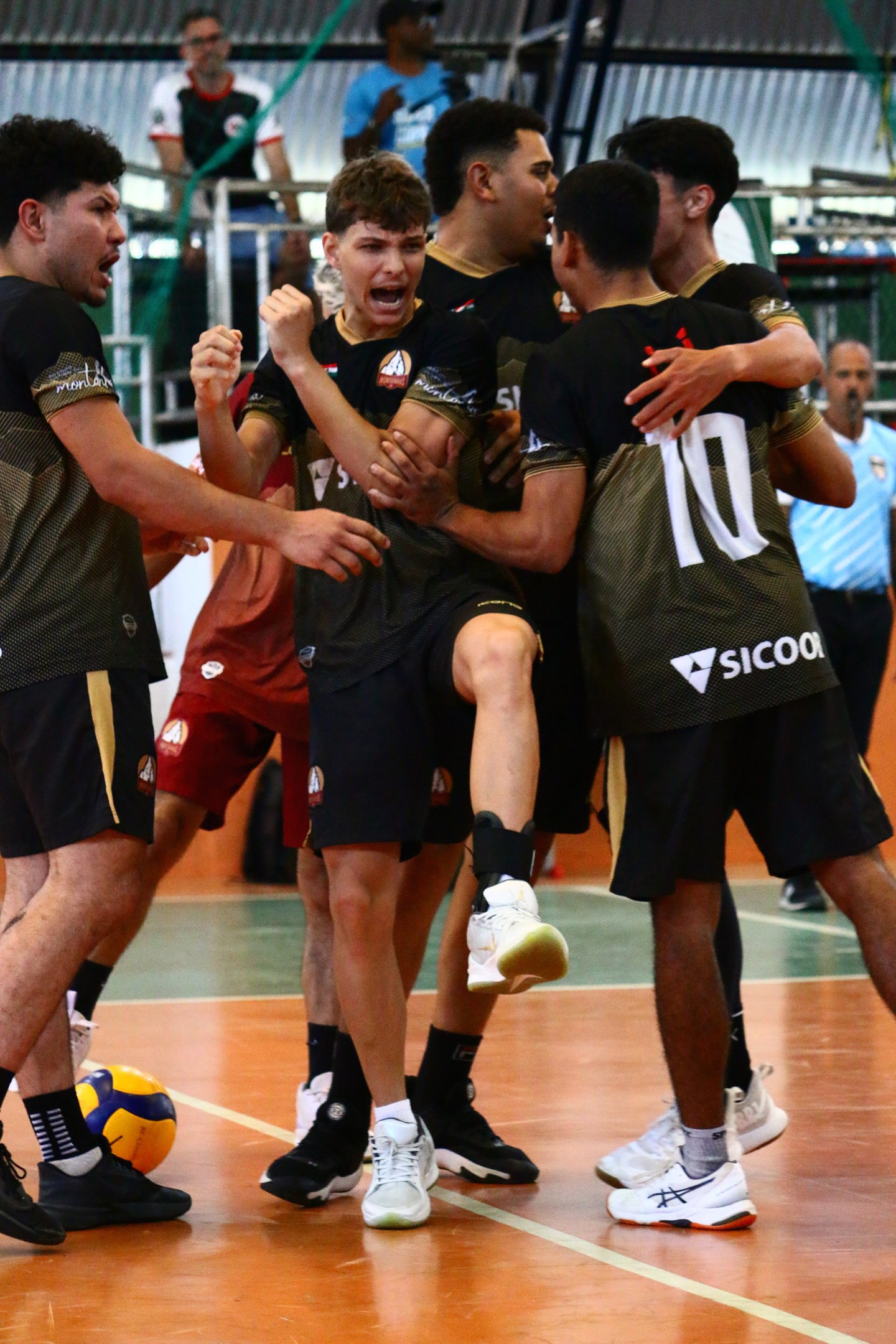 Time de voleibol comemorando ponto abraçado