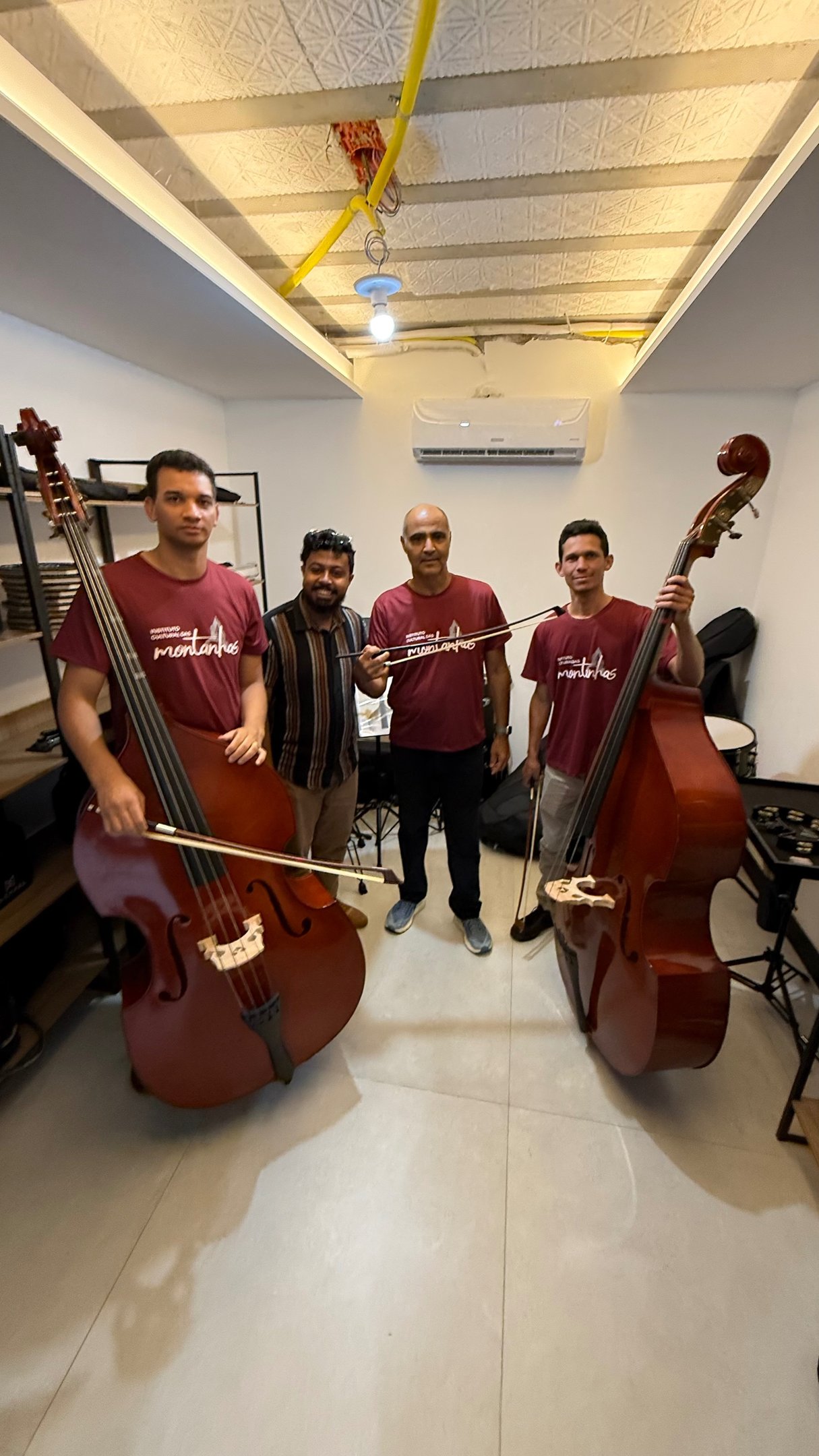 Alunos da Orquestra Jônice Tristão com contrabaixos acústicos